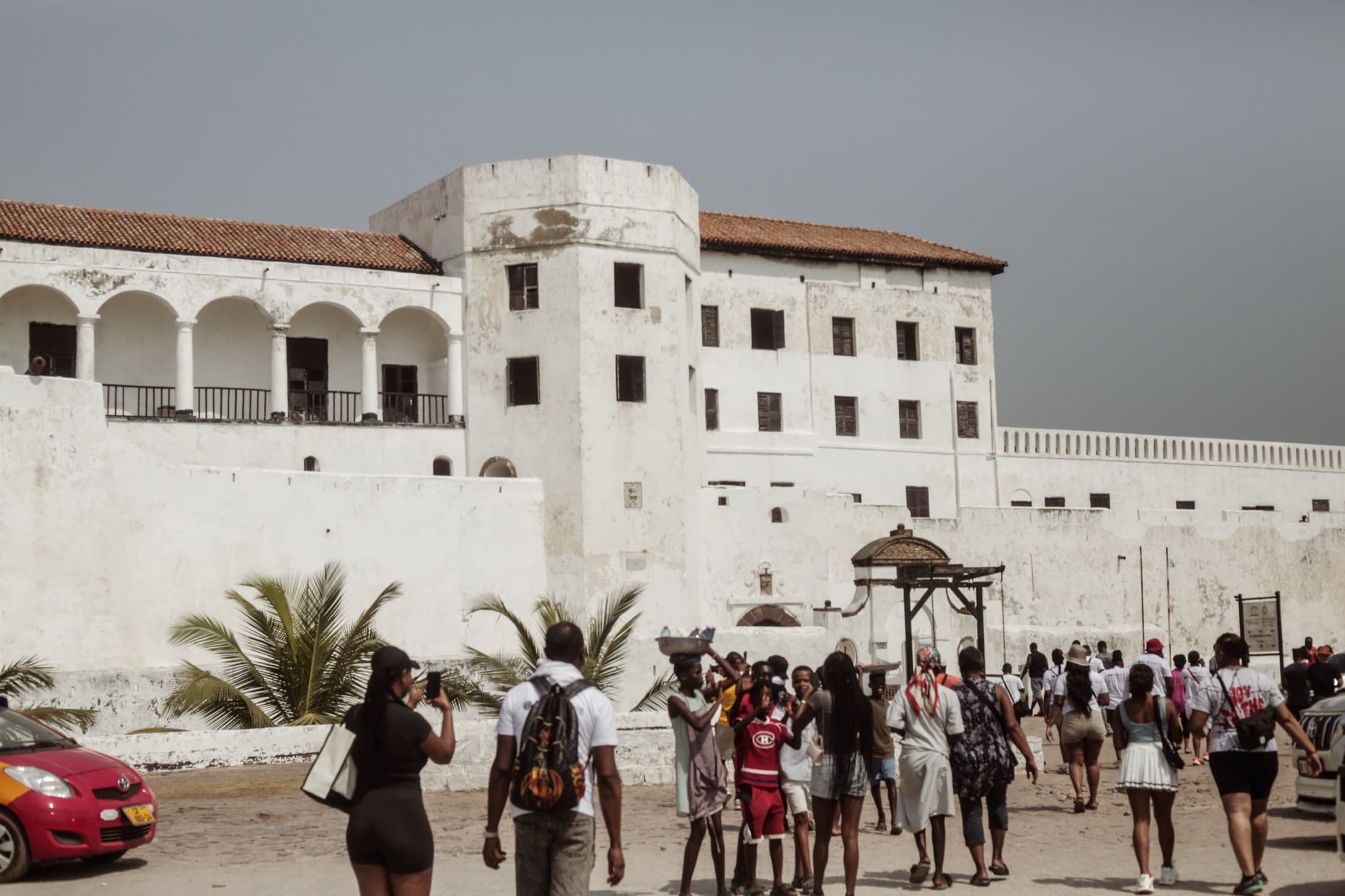 Visitors walking toward the gate of Elmina Castle on the Ghanaian coast