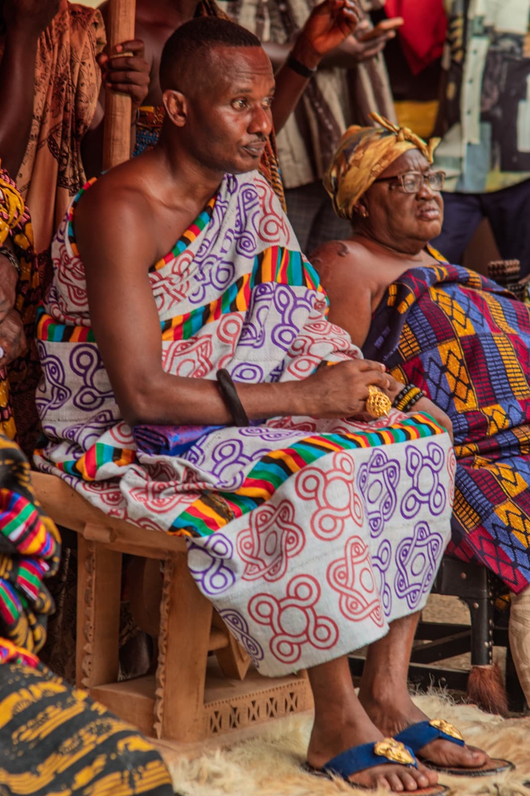 A chief seated in kente among elders at a traditional gathering